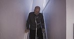 Stairs, crutches and senior man with a disability, accident or medical injury in a house. Elderly man walking on steps for exercise of muscle, health and fitness during rehabilitation of body