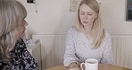 Advice, mother and child with coffee during communication about a problem, stress or idea in a house. Senior mom listening to her adult daughter talk with support, love and drink of tea in a home