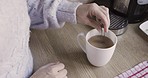 Hand, coffee and spoon stir with a woman make a beverage in the kitchen of her home from above. House, mug and stirring with a female preparing a caffeine drink on a domestic counter top alone