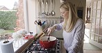 Cooking, pot and woman in the kitchen of her house for healthy food for dinner. Breakfast, diet and chef with a smile while stirring vegan fine dining on the stove of her house in the morning