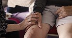 Senior couple, knee or leg injury care for elderly man at home for rehabilitation after orthopedic surgery for osteoporosis, fibromyalgia or arthritis. Help, support and empathy of woman for partner