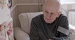 Retirement, elderly and man tired in chair with rehabilitation crutches talking in nursing home with sleepy yawn. Pension, thinking and exhausted senior guy speaking at retirement home.


