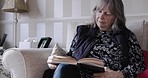 Book, senior woman and on sofa for reading, relax and content in living room being calm. Mature female, elderly lady and study bible, with novel and concentrate being peaceful, on couch and in lounge