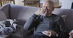 Elderly man, drinking pills and living room sofa for health, wellness and healthy heart, cancer or diabetes in home. Senior, retirement or healthcare for medical self care, medicine or drugs in house