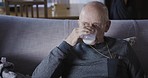 Senior man drinking milk in living room for healthy lifestyle, morning breakfast and nutrition while using phone, technology and 5g app on sofa. Old man, glass of milk and reading mobile notification