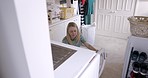 Washing machine, laundry and woman with basket for clothes, fabric and housekeeping for cleaning fresh home. Mature lady remove clothing from dryer, electrical appliance and routine lifestyle tasks 