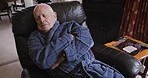 Sleeping, comfortable and senior man on sofa in pajamas resting in living room of retirement home. Rehabilitation, healing and tired elderly man wrap himself for warmth, comfort and heat in cold air