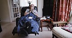 Sick, senior and man blowing his nose with flu while relaxing on sofa in living room at home. Coughing, sneezing and retired elderly man in recovery from illness or cold with rest in lounge of house.