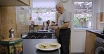 Cooking senior man, breakfast and food in a retirement nursing home in the morning. Elderly person or retired chef in a house kitchen making a healthy lunch meal for people in a home to eat