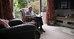 Retirement, reading and senior man with glasses enjoying peace, quiet and free time in nursing home. Wellness, leisure and elderly male put on eyewear to read book, novel and story sitting in chair