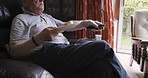 Watching tv, eating and senior man on sofa enjoying freedom, retirement and relaxing at home. Entertainment, television and elderly male sitting on couch, eat lunch and switch channel with remote