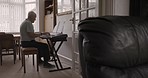 Retired musician and man playing keyboard in his retirement home for fun practice while using music notes. Instrument, piano keyboard and elderly male player in his house enjoying music