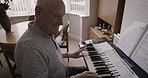 Senior man, enjoy or playing piano in song composition, music sheet education or jazz learning in house or home living room. Smile, happy musician or retirement elderly on pianist musical instrument