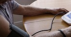 Healthcare retirement blood pressure test, senior man at living room table in nursing home. Medical treatment, senior care and old man testing circulation or vital signs with wireless monitor in home