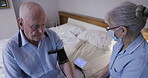 Old man with nurse, blood pressure machine for health check and retirement in nursing home. Medical care, wellness and elderlly with cardiovascular healthcare, woman in face mask and caregiver