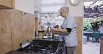 Kitchen, caregiver or senior nurse and tea at nursing home or rehabilitation center at breakfast time. Healthcare, support and elderly woman with teapot working in elderly care with drink on visit