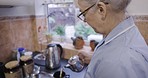 Kitchen, caregiver or nurse pouring tea in cup in nursing home or rehabilitation center at breakfast time. Healthcare, support and elderly woman working in senior care making coffee while on visit.