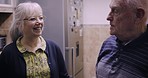 Laughing, happy and senior couple talking with love, smile and joke in retirement. Comic, funny and elderly man speaking to a woman about a story in the kitchen holiday in the morning together