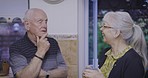 Elderly couple, happy and coffee In a kitchen, smile and talking in their home together. Tea, love and senior woman with man, joke and humor while enjoying retired lifestyle, bonding and cheerful 