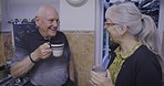 Laughing, coffee and senior couple talking about retirement, joke and funny story in the kitchen. Peace, smile and elderly man and woman with tea drink, conversation and enjoying company in a home