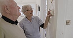 Assisted living, thermostat and dial with a woman nurse showing a man patient the temperature control in his home. Retirement, heating or switch with a female medicine professional and male resident