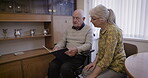 Mature couple with album, memory and life together, retirement and relax with communication and pictures. Love, care and retired people in nursing home, memories and talking with old man and woman