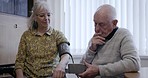 Blood pressure, senior care and elderly couple bond while testing blood, heart or cardiovascular health in their home. Hypertension, old people and man with woman for monitoring, checking and talking