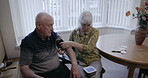 Blood pressure monitor, senior people and home check of medical test, cholesterol or hypertension. Old couple, arm pulse and monitor heart healthcare, diabetes or cardiovascular wellness in apartment