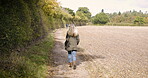 Walking, back view and woman outdoors on a farm, land and nature in the countryside on vacation or holiday. Lonely, alone and female farmer on farmland to clear her mind for peace and calm
