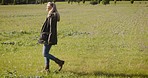 Nature, walk and woman in a field for adventure while on a summer countryside holiday or weekend trip. Forest, explore and lady walking outdoor on green grass in a garden while on vacation in Canada.