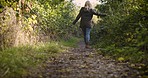 Happy woman, walking and celebrating freedom in nature for travel, trip or adventure in the countryside. Blond female enjoying walk and twirling in joyful happiness for natural environment outdoors