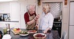 Love, happiness and senior couple in kitchen cooking lunch, healthy food and vegetable diet in retirement. Happy woman, old man in apron and conversation with meal prep, marriage bonding in apartment