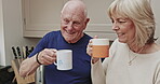 Happy, cheers and senior couple drinking coffee, bonding over celebration or achievement and success in the kitchen in the morning. Elderly man and woman speaking with a cup of tea together at home