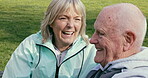 Happy senior couple outdoor and in love, spending quality time together in nature on a bench. Retirement and man and woman enjoy a relax day in a park or garden