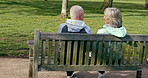 Happy senior couple outdoor and in love, spending quality time together in nature on a bench. Retirement and man and woman enjoy a relax day in a park or garden