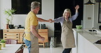Senior couple, dance in kitchen and smile with love while making breakfast in their home. Happy old man, dancing with smiling elderly woman and fun in retirement together while cooking