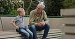 Senior man and grandson bonding together in a garden with conversation and support. Love, relationship and advice with a relax grandfather having a discussion with family