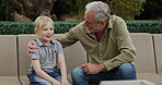 Senior man and grandson bonding together in a garden with conversation and support. Love, relationship and advice with a relax grandfather having a discussion with family