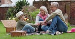 Grandson, family in garden on a picnic on holiday or vacation with a boy. Happy grandparents, man and woman with child bonding and relax