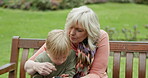 Grandmother, young boy and kid with cellphone on park bench for games, app and social media. Senior woman, grandchild and smartphone in garden for connection, download and reading notification
