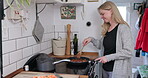 Smile, kitchen and woman cooking food on stove with frying pan for healthy meal in home. Happy, chef or hungry person preparing breakfast for wellness, nutrition or vegan diet in the morning in house