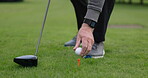 Hands, golf ball and driver or tee, sports and competition on grass, challenge and tournament. Person, athlete and ready for game, practice and hobby or recreation, action and equipment for match