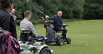 Golf course, exercise and man swing club in nature or outdoor in competition. Golfers, group and back of person with a disability, wheelchair and driver in game, healthy training and applause sport