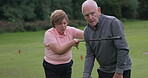 Couple, golf and talking on course or sport communication, swing shot practice or point strategy. Old people, game equipment or green field speaking or winning, action stroke or outdoor club hobby