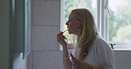 Lipstick, morning and a woman getting ready in the bathroom of her home to start the day. Mirror, makeup or cosmetics with a person in an apartment to apply color to her lips for a beauty routine
