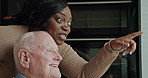 Senior, man or caregiver with pointing or wheelchair for support, conversation and happy in kitchen. Elderly, person or woman with communication, talking and handicap in retirement home for volunteer