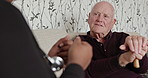 Discussion, healthcare and nurse with senior man with a walking stick in living room of house. Communication, medical and back of African caregiver talking to elderly male patient in retirement home.