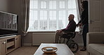 Woman, volunteer and senior patient in wheelchair for support, healthcare assistance or help at old age home. Female caregiver or nurse pushing elderly man or person with a disability in living room