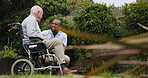 Elderly man, wheelchair and person in park garden or retiree with a disability, mobility help or connection. Male individual, friends and backyard for talking in summer sun or rest, peace or relax