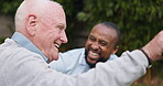 Smile, conversation and old man with caregiver at garden, park or outdoor in wheelchair. Funny elderly person with a disability, talk to nurse and laughing in rehabilitation, healthcare and support